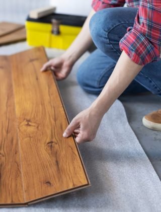 man-worker-installing-laminate-flooring-wooden-laminate-floor-plank-and-tools.jpg